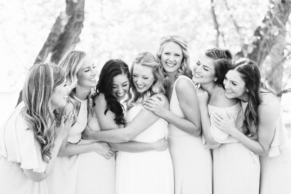 bride and her girls hugging at the lake house
